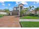 Beautiful home featuring a barrel tile roof, a brick paver driveway, and tropical landscaping at 12279 Canavese Ln, Venice, FL 34293