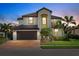Beautiful two-story home featuring a tile roof, manicured lawn, and lush tropical landscaping at 12279 Canavese Ln, Venice, FL 34293