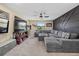 Large living room with sectional sofa, mounted television, and stylish wall accents at 12279 Canavese Ln, Venice, FL 34293