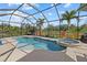 Screened-in pool and spa surrounded by pavers and tropical landscaping with a lake view at 12279 Canavese Ln, Venice, FL 34293