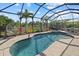 Screened-in pool and spa with views of a lake and lush landscaping at 12279 Canavese Ln, Venice, FL 34293