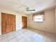 Standard bedroom featuring tile floors, a ceiling fan, and closet space at 12321 Alta Mira St, North Port, FL 34287