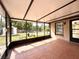 Enclosed patio with tile flooring offers a relaxing outdoor living space with views of the yard and a shed at 12321 Alta Mira St, North Port, FL 34287