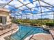 Inviting screened-in pool with an adjacent patio, lush landscaping, and a serene view at 1241 Reserve Dr, Venice, FL 34285