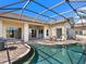 Outdoor living space showcasing a screened pool, patio area with seating, and the home's exterior at 1241 Reserve Dr, Venice, FL 34285