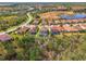 Scenic aerial shot captures a home with a screened pool, backing onto a wooded area in a residential community at 12410 Cinqueterre Dr, Venice, FL 34293