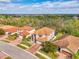 Aerial view of the home showcasing the tile roof, brick driveway, and mature landscaping at 12410 Cinqueterre Dr, Venice, FL 34293