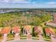 A picturesque aerial view of a neighborhood with lush green trees, lake and tile-roofed homes at 12410 Cinqueterre Dr, Venice, FL 34293
