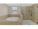 Bright bathroom with a bathtub and separate glass enclosed shower at 12410 Cinqueterre Dr, Venice, FL 34293