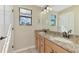 Bathroom featuring double sinks with granite countertop and warm wood cabinetry at 12410 Cinqueterre Dr, Venice, FL 34293