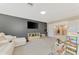 Bonus room with gray accent wall, large TV, and neutral-toned furniture at 12410 Cinqueterre Dr, Venice, FL 34293