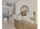 Inviting entryway with tiled floors, staircase, and decorative mirror over a wooden cabinet at 12410 Cinqueterre Dr, Venice, FL 34293