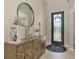Home entryway featuring a decorative wooden cabinet, a round mirror, and a stylish front door at 12410 Cinqueterre Dr, Venice, FL 34293