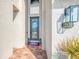 Front door with decorative glass, house number, stylish lighting fixtures, and a beautiful brick walkway at 12410 Cinqueterre Dr, Venice, FL 34293