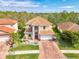 Beautiful two-story home featuring a tile roof, brick driveway, a two-car garage, and lush landscaping at 12410 Cinqueterre Dr, Venice, FL 34293