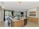View of kitchen island featuring granite countertops and a seamless transition to the living room at 12410 Cinqueterre Dr, Venice, FL 34293