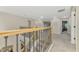 Spacious upper landing featuring modern railing and doorways to bedrooms and sitting areas at 12410 Cinqueterre Dr, Venice, FL 34293