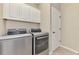Bright laundry room featuring modern washer and dryer with white cabinets above at 12410 Cinqueterre Dr, Venice, FL 34293