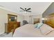 Cozy main bedroom featuring a ceiling fan, dresser, and comfortable furnishings at 12410 Cinqueterre Dr, Venice, FL 34293