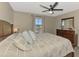 Comfortable main bedroom featuring a ceiling fan, dresser, and a neutral color scheme at 12410 Cinqueterre Dr, Venice, FL 34293