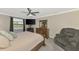 Comfortable main bedroom featuring a king bed, ceiling fan, and decorative furnishings at 12410 Cinqueterre Dr, Venice, FL 34293