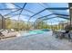 Beautiful screened-in pool area with travertine deck, basketball hoop, and lounge chairs at 12410 Cinqueterre Dr, Venice, FL 34293