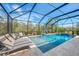 Inviting screened pool with basketball hoop, lounge chairs, and mature landscaping at 12410 Cinqueterre Dr, Venice, FL 34293