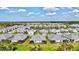 Aerial shot of a neighborhood with blue homes, gray roofs, and a scenic pond at 12505 Palatka Dr, Venice, FL 34293