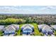 Aerial view of blue homes with well-manicured lawns and a lush green backdrop at 12505 Palatka Dr, Venice, FL 34293