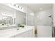 Well-lit bathroom featuring double vanity, large mirror, and glass-enclosed shower at 12505 Palatka Dr, Venice, FL 34293
