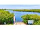 Wooden boat ramp with access to the waterway surrounded by lush foliage at 12505 Palatka Dr, Venice, FL 34293