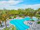 Aerial view of pool with geometric patterned pool deck, lounge seating, and mature landscaping at 12505 Palatka Dr, Venice, FL 34293