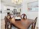 Dining area showcasing a wooden table and chairs adjacent to a modern kitchen with white cabinets at 12505 Palatka Dr, Venice, FL 34293
