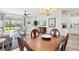 Dining area with a wooden table and chairs, chandelier, and an open view of the living room and backyard at 12505 Palatka Dr, Venice, FL 34293