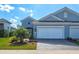 Attractive blue home with a two-car garage and landscaped front yard at 12505 Palatka Dr, Venice, FL 34293