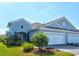 Charming blue home featuring a well-maintained lawn and two-car garage at 12505 Palatka Dr, Venice, FL 34293