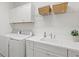Efficient laundry room boasts modern appliances, ample counter space, and bright white cabinets for organized living at 12505 Palatka Dr, Venice, FL 34293