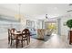 Open-concept living and dining area with hardwood floors, stylish furniture, and access to an outdoor patio at 12505 Palatka Dr, Venice, FL 34293