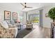 Bright living room with a comfortable seating arrangement, a ceiling fan, and access to the outdoor patio area at 12505 Palatka Dr, Venice, FL 34293