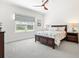 Bright main bedroom featuring a wooden bed frame, blind-covered windows, and neutral paint at 12505 Palatka Dr, Venice, FL 34293
