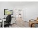 Home office with a desk, chair, and a view into the kitchen through a set of glass doors at 12505 Palatka Dr, Venice, FL 34293