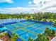 Outdoor pickleball courts surrounded by blue fencing and lush landscaping near a tranquil lake at 12505 Palatka Dr, Venice, FL 34293
