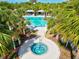 Relaxing community pool area with a hot tub, palm trees, and shaded seating at 12505 Palatka Dr, Venice, FL 34293