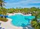 Beautiful swimming pool with a slide, surrounded by palm trees, and lounge areas at 12505 Palatka Dr, Venice, FL 34293
