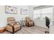 Cozy sitting area featuring two comfortable armchairs, a side table, and a window with blinds for natural light at 12505 Palatka Dr, Venice, FL 34293
