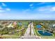 Aerial perspective of the community entrance, golf course, lakes, and lush landscaping at 1298 Highland Greens Dr, Venice, FL 34285