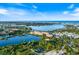 An aerial view of homes on a waterway shows the water, land, vegetation, and nearby buildings at 1298 Highland Greens Dr, Venice, FL 34285