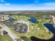 High-angle view of the community's layout, featuring a golf course, lakes, and recreational amenities at 1298 Highland Greens Dr, Venice, FL 34285