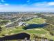 Wide aerial shot showcasing the community, its golf course, interconnected waterways, and residential areas at 1298 Highland Greens Dr, Venice, FL 34285