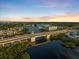 A high-angle shot of a bridge over the water showing residences in the distance at sunset at 1298 Highland Greens Dr, Venice, FL 34285